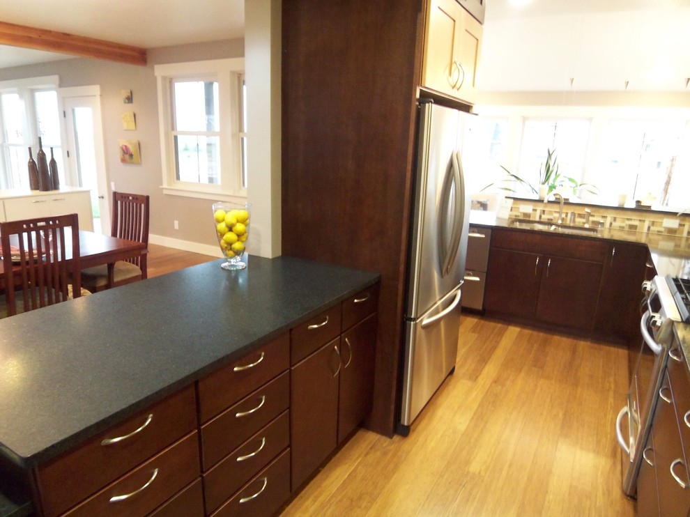 Example of a mid-sized transitional galley bamboo floor eat-in kitchen design with an undermount sink, shaker cabinets, dark wood cabinets, quartz countertops, beige backsplash, ceramic backsplash, stainless steel appliances and a peninsula