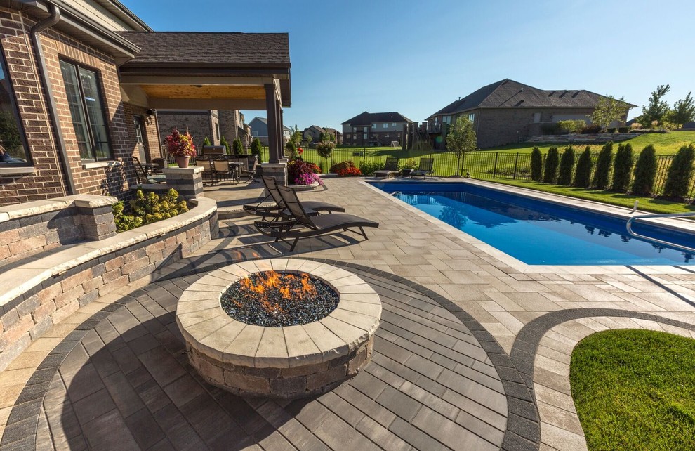 Design ideas for a contemporary backyard patio in Other with a fire feature, concrete pavers and a roof extension.