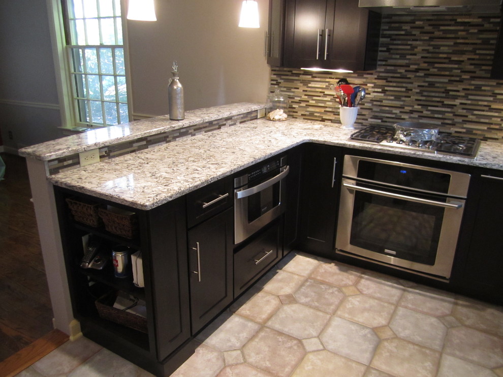 Eat-in kitchen - transitional u-shaped eat-in kitchen idea in St Louis with an undermount sink, shaker cabinets, dark wood cabinets, granite countertops, multicolored backsplash and stainless steel appliances