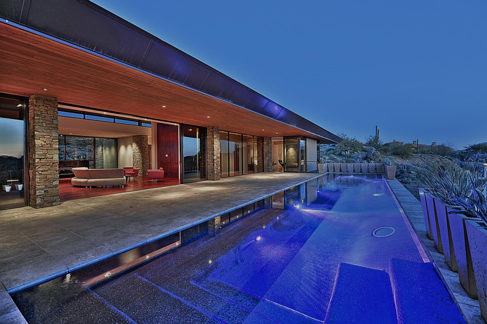This is an example of a large contemporary backyard rectangular lap pool in Phoenix.