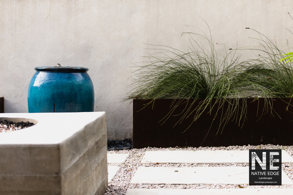 Inspiration for a small modern courtyard xeriscape in Austin with concrete pavers and a container garden.