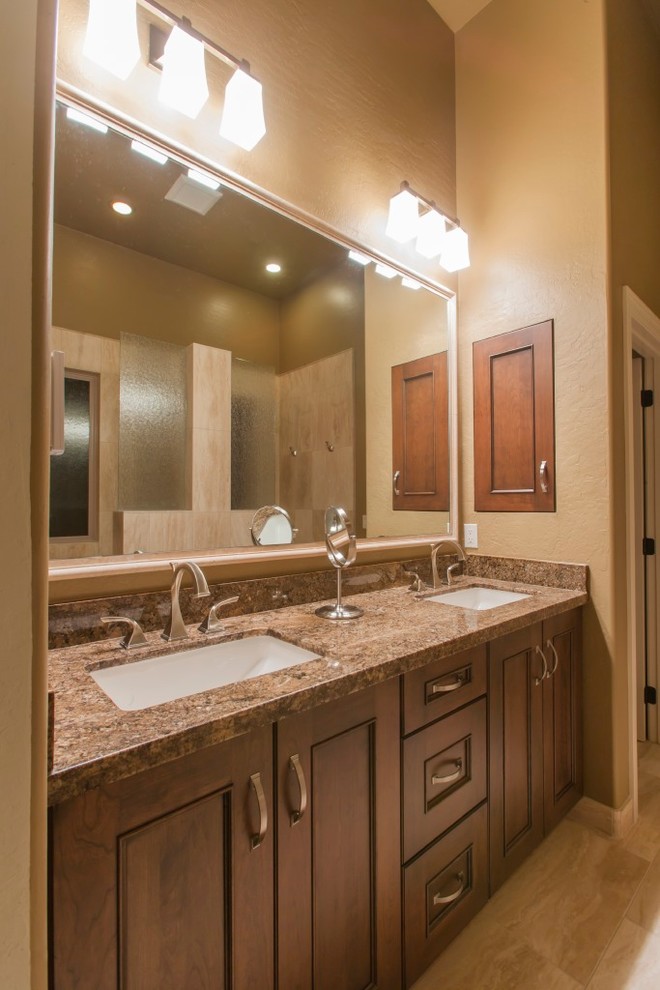 Mid-sized traditional master bathroom in Phoenix with recessed-panel cabinets, dark wood cabinets, an open shower, a two-piece toilet, beige walls, porcelain floors, an undermount sink, granite benchtops and brown benchtops.