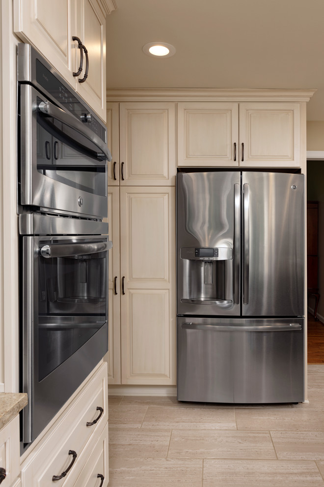 Large transitional l-shaped ceramic tile eat-in kitchen photo in DC Metro with raised-panel cabinets, white cabinets, glass tile backsplash, stainless steel appliances, an island, an undermount sink, quartz countertops and beige backsplash