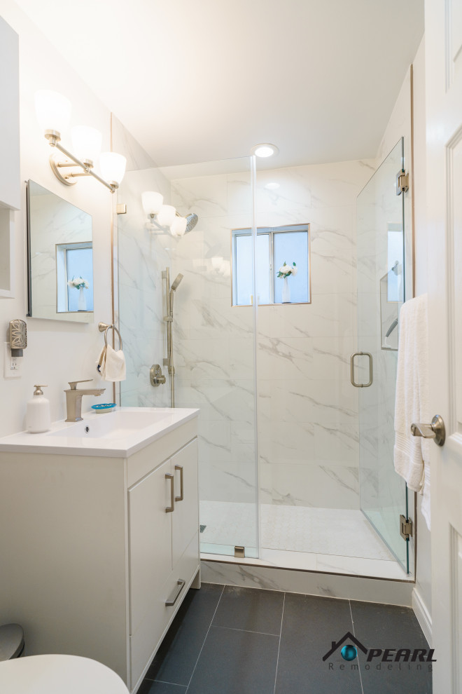 This is an example of a small modern ensuite bathroom in Los Angeles with flat-panel cabinets, white cabinets, an alcove shower, a two-piece toilet, white tiles, marble tiles, white walls, cement flooring, a built-in sink, solid surface worktops, black floors, a hinged door, white worktops, a single sink and a built in vanity unit.