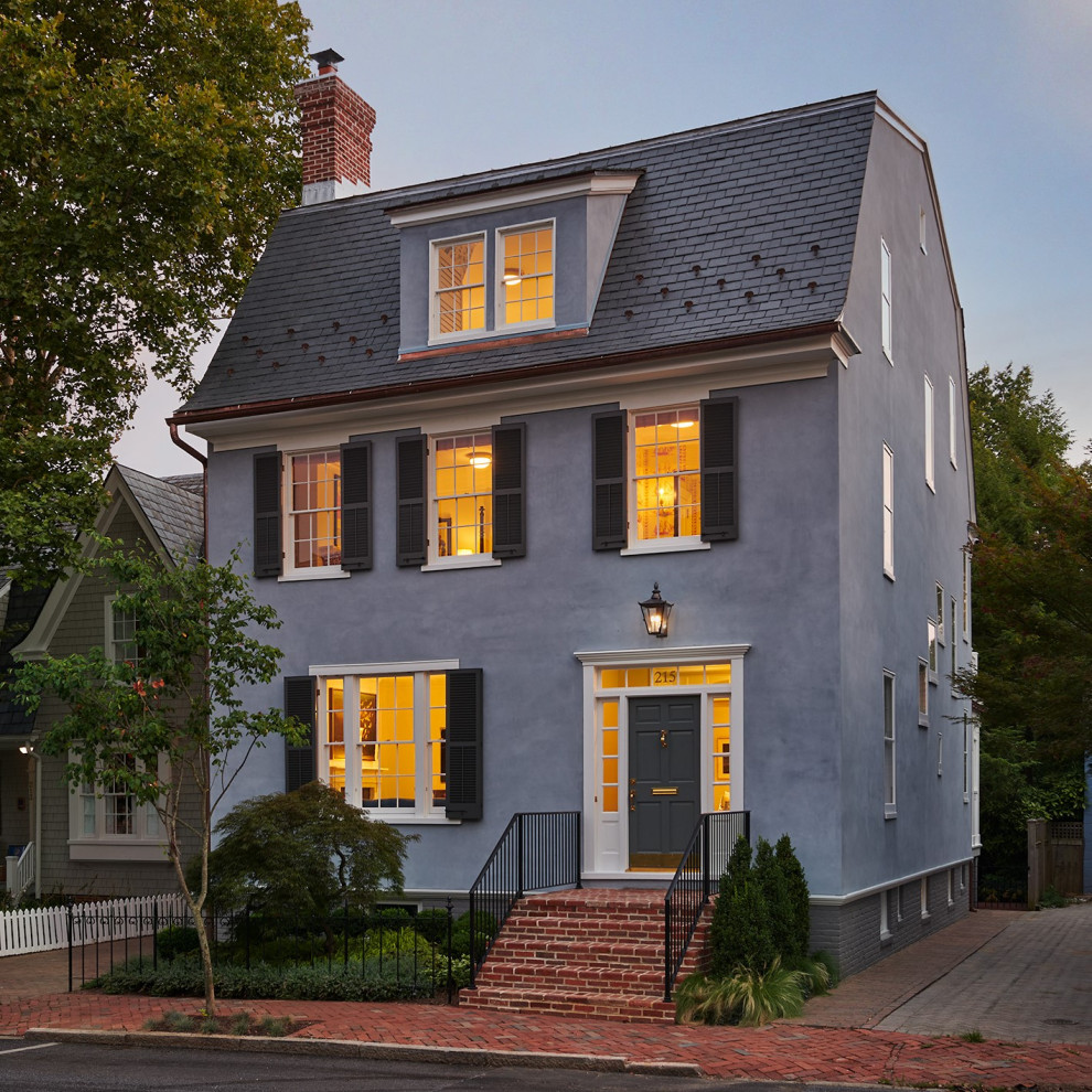 Inspiration for a mid-sized traditional stucco blue house exterior in DC Metro with four or more storeys, a gambrel roof and a grey roof.