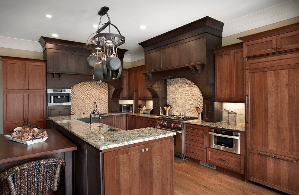 Photo of a transitional l-shaped kitchen in Charleston with an undermount sink, recessed-panel cabinets and dark wood cabinets.