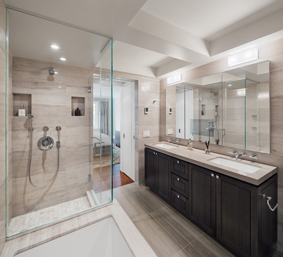 This is an example of a mid-sized transitional master bathroom in New York with an undermount sink, shaker cabinets, dark wood cabinets, an undermount tub, a corner shower, beige tile, grey floor, porcelain tile, beige walls and porcelain floors.