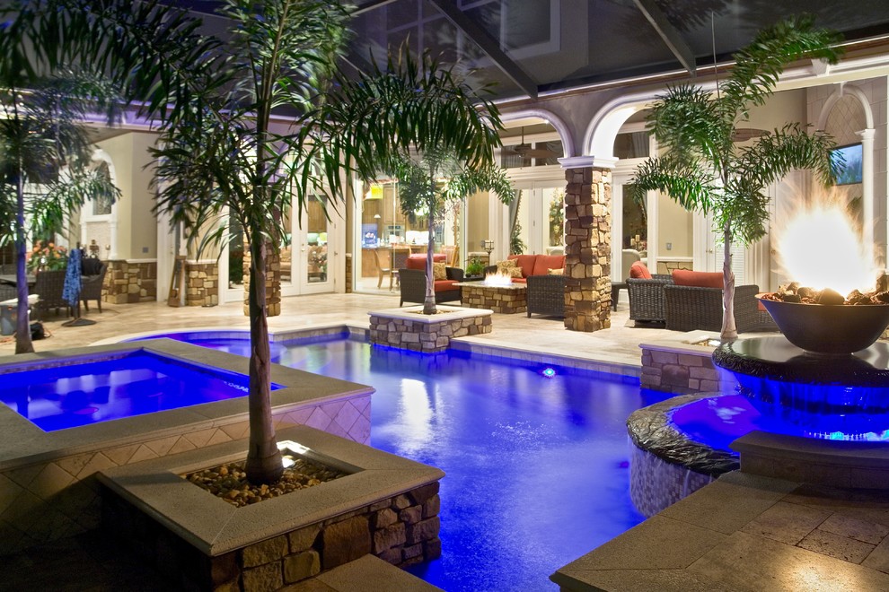 Mid-sized tuscan backyard stone and custom-shaped pool photo in Tampa
