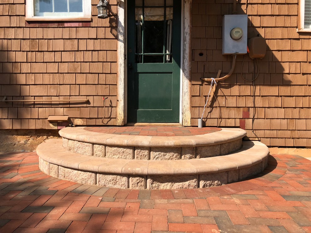 This is an example of a large country backyard patio in Richmond with brick pavers and no cover.