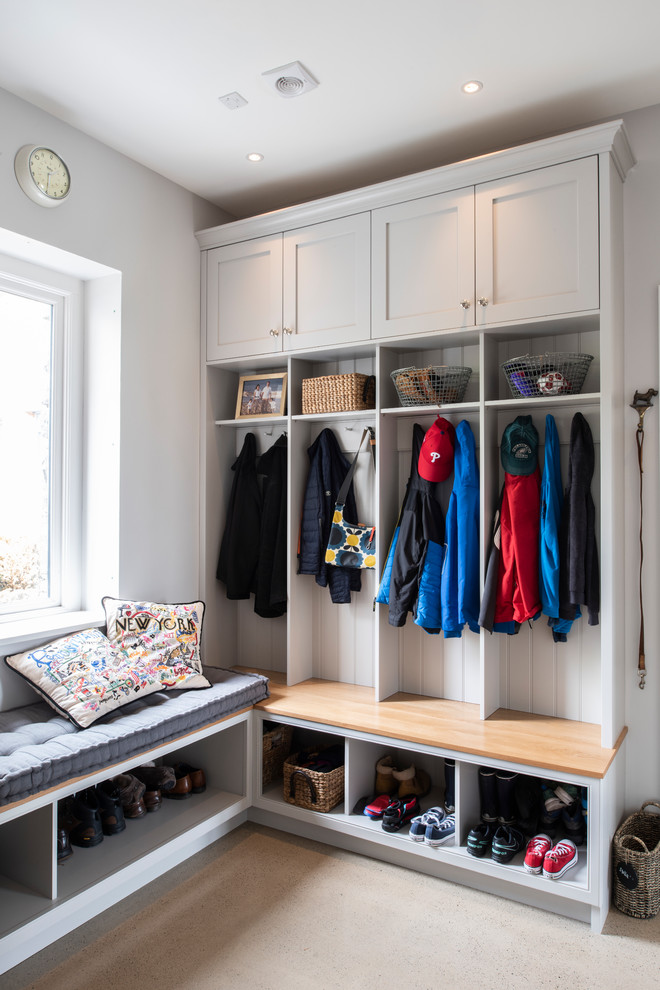 Inspiration for a mid-sized transitional mudroom in London with grey walls and beige floor.