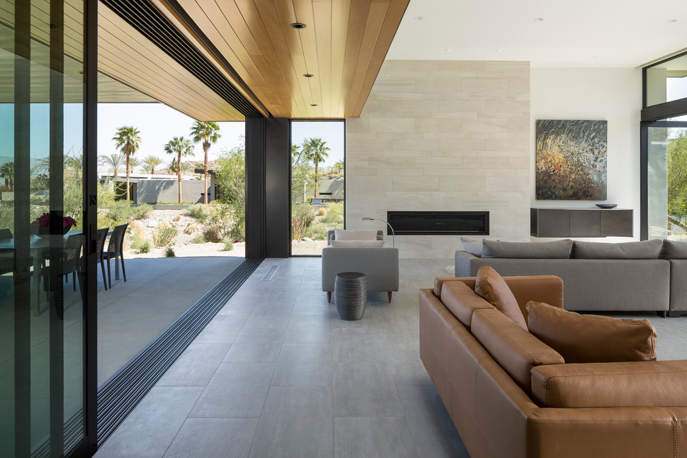 Inspiration for a large modern open concept living room in Los Angeles with white walls, porcelain floors, a ribbon fireplace, a stone fireplace surround, a concealed tv and grey floor.