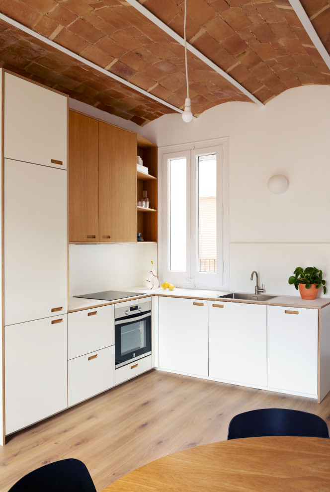 Design ideas for a mid-sized contemporary l-shaped separate kitchen in Other with an integrated sink, shaker cabinets, white cabinets, laminate benchtops, white splashback, ceramic splashback, stainless steel appliances, plywood floors, brown floor, white benchtop and coffered.
