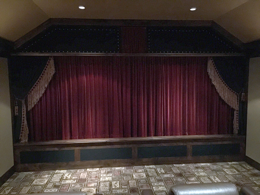 Photo of a mid-sized eclectic enclosed home theatre in Oklahoma City with beige walls, carpet and a projector screen.