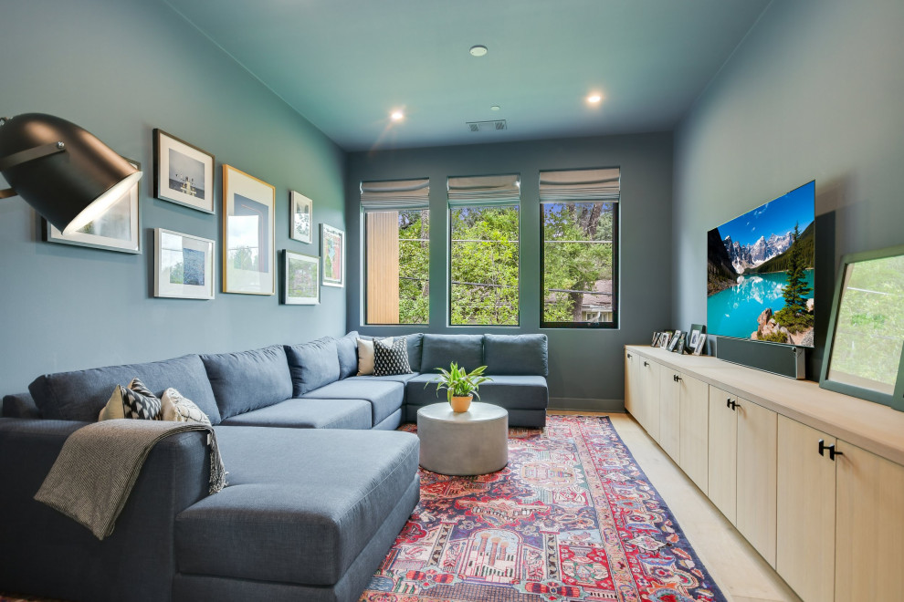 Ispirazione per un soggiorno moderno di medie dimensioni e chiuso con pareti blu, parquet chiaro e TV a parete