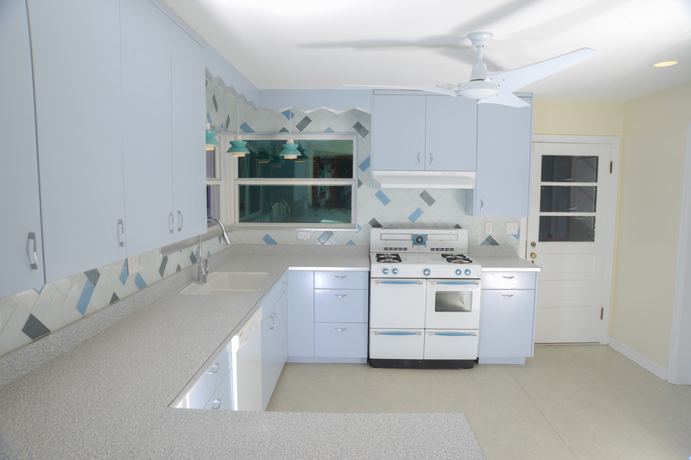 Photo of a mid-sized midcentury u-shaped eat-in kitchen in Miami with an integrated sink, flat-panel cabinets, laminate benchtops, glass tile splashback, blue cabinets, beige splashback, linoleum floors, no island and beige floor.