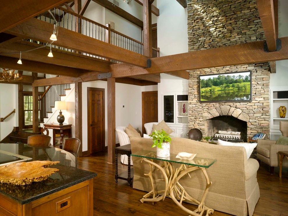 Inspiration for a large country open concept family room in Atlanta with white walls, dark hardwood floors, a standard fireplace, a stone fireplace surround and a wall-mounted tv.