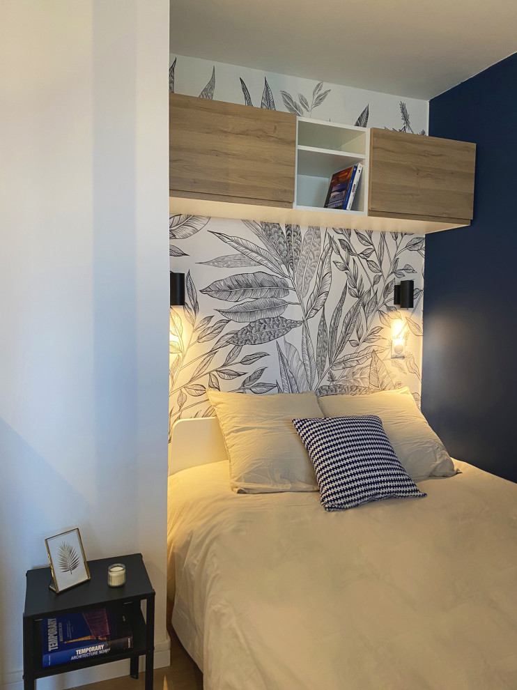 Cette image montre une petite chambre minimaliste avec un mur bleu, sol en stratifié, aucune cheminée, un sol beige, du papier peint et verrière.