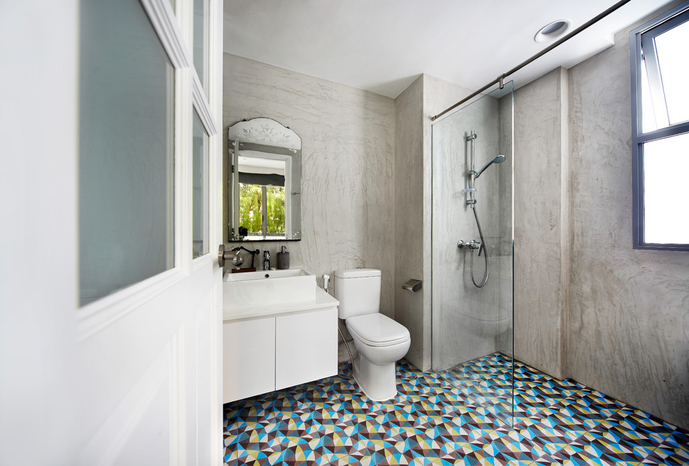 Inspiration for an industrial 3/4 bathroom in Singapore with flat-panel cabinets, white cabinets, a curbless shower, a one-piece toilet, multi-coloured tile, grey walls, a vessel sink and an open shower.