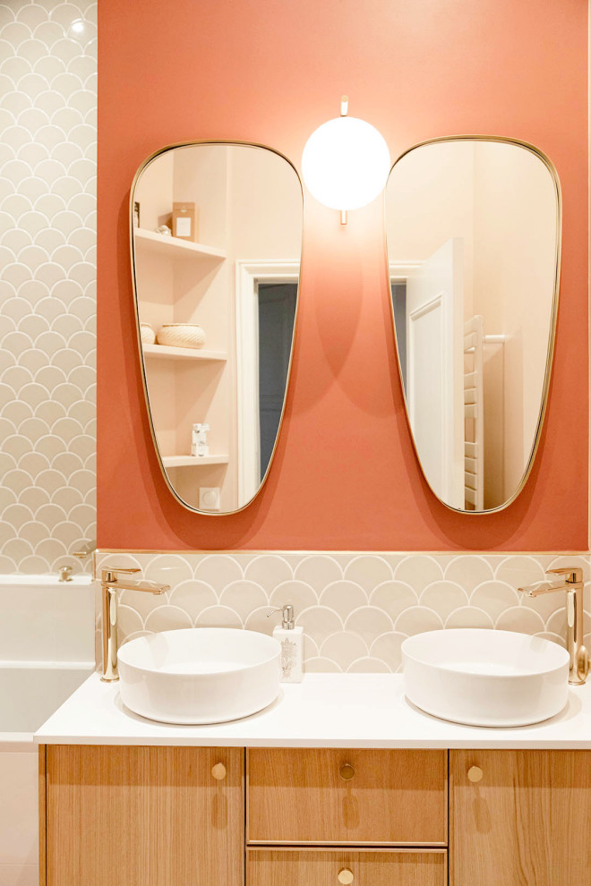 На фото: главная ванная комната среднего размера с плоскими фасадами, светлыми деревянными фасадами, накладной ванной, душем над ванной, розовой плиткой, керамической плиткой, красными стенами, полом из терраццо, настольной раковиной, столешницей из искусственного камня, разноцветным полом, открытым душем, белой столешницей, нишей, тумбой под две раковины и напольной тумбой