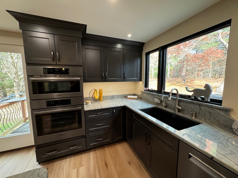 Inspiration for a mid-sized transitional u-shaped laminate floor and brown floor eat-in kitchen remodel in Boston with an undermount sink, shaker cabinets, brown cabinets, quartz countertops, black appliances, an island and multicolored countertops