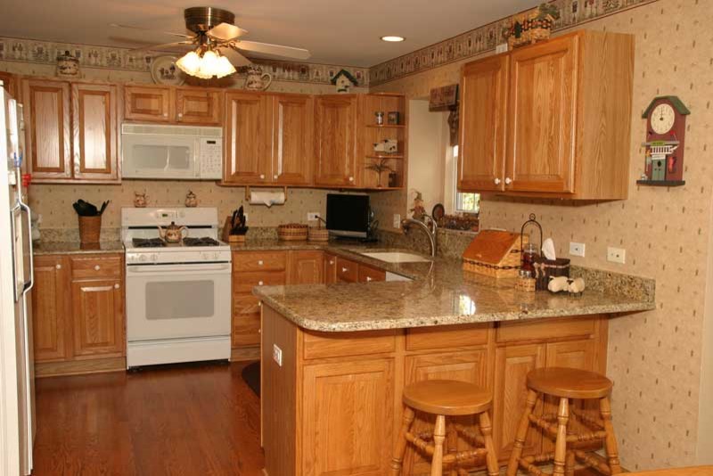 Inspiration for a transitional u-shaped medium tone wood floor kitchen pantry remodel in Chicago with raised-panel cabinets, medium tone wood cabinets and granite countertops