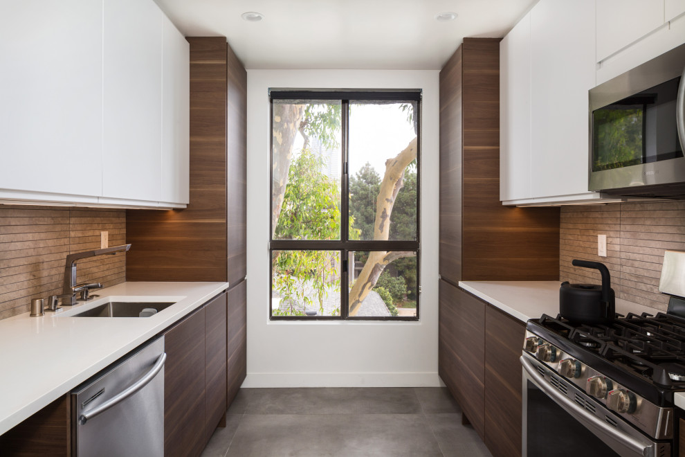 Design ideas for a small contemporary galley separate kitchen in Los Angeles with an undermount sink, flat-panel cabinets, dark wood cabinets, quartz benchtops, grey splashback, limestone splashback, stainless steel appliances, concrete floors, no island, grey floor and white benchtop.