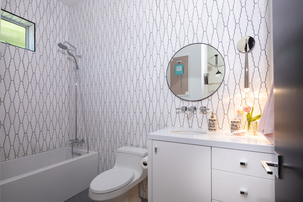 Design ideas for a mid-sized contemporary kids bathroom in Orange County with flat-panel cabinets, white cabinets, a one-piece toilet, white tile, marble, an undermount sink, engineered quartz benchtops, black floor, white benchtops, an alcove tub, a shower/bathtub combo and mosaic tile floors.