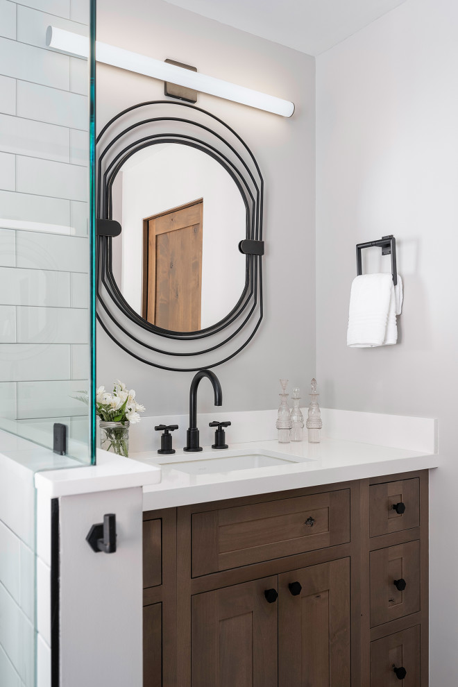 Small country bathroom in Other with shaker cabinets, brown cabinets, a corner shower, a one-piece toilet, white tile, subway tile, grey walls, porcelain floors, an undermount sink, engineered quartz benchtops, white floor, a sliding shower screen, white benchtops, a single vanity and a built-in vanity.