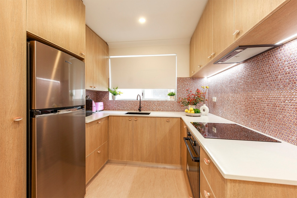 Small contemporary u-shaped kitchen in Sydney with a drop-in sink, light wood cabinets, quartz benchtops, pink splashback, cement tile splashback, stainless steel appliances, vinyl floors, no island, pink floor and white benchtop.