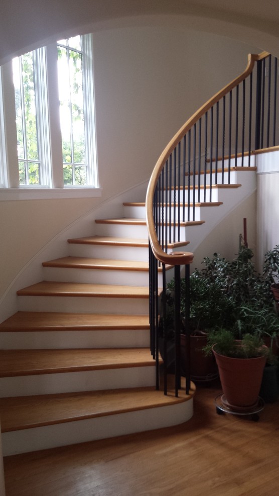 Small traditional wood curved staircase in Denver with painted wood risers.