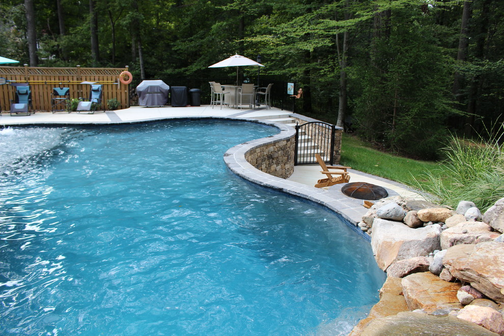 Large mountain style backyard custom-shaped natural pool fountain photo in DC Metro with decking