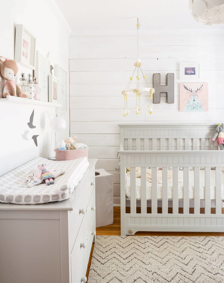 Mid-sized country nursery in Toronto with white walls and medium hardwood floors for girls.