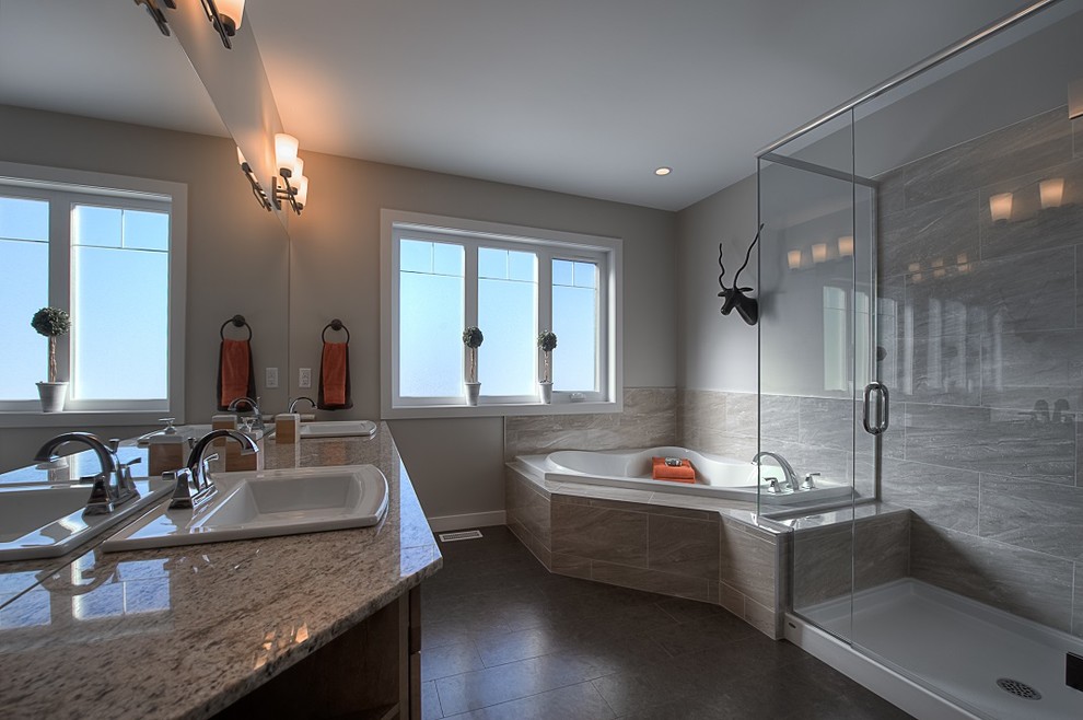 This is an example of a large country master bathroom in Other with a drop-in sink, shaker cabinets, medium wood cabinets, granite benchtops, a corner tub, a corner shower, a two-piece toilet, beige tile, ceramic tile, beige walls and cork floors.
