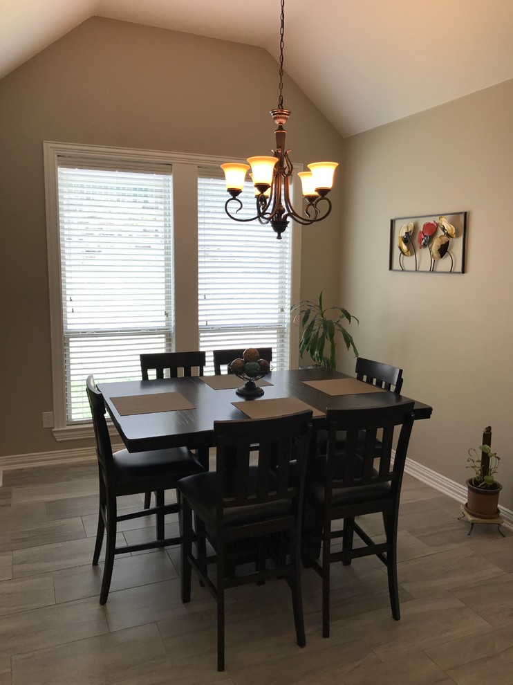 Kitchen/dining room combo - small transitional porcelain tile kitchen/dining room combo idea in Austin with gray walls, a corner fireplace and a stone fireplace