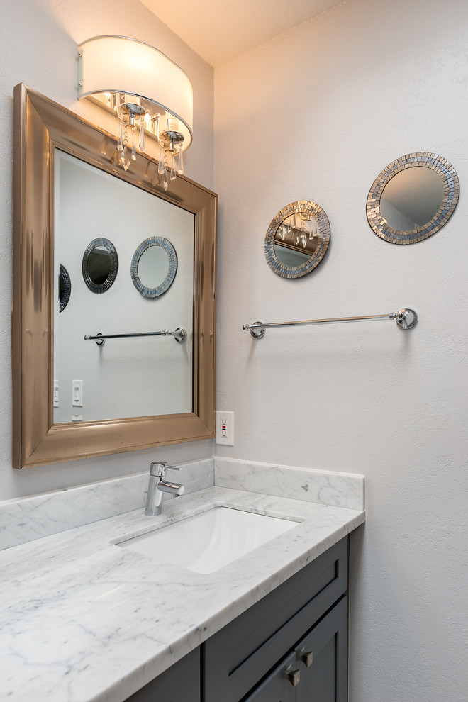 Large transitional master white tile and marble tile travertine floor and beige floor alcove shower photo with shaker cabinets, gray cabinets, a two-piece toilet, beige walls, an undermount sink, quartzite countertops and white countertops