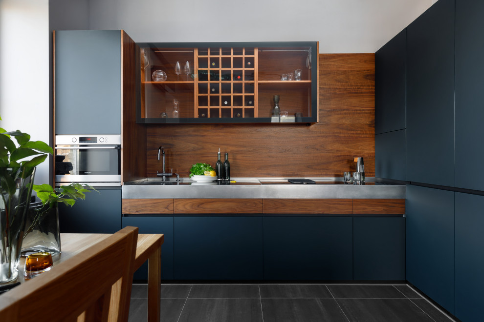 Photo of a mid-sized contemporary l-shaped eat-in kitchen in Moscow with a single-bowl sink, black cabinets, stainless steel benchtops, brown splashback, timber splashback, panelled appliances, no island and grey benchtop.