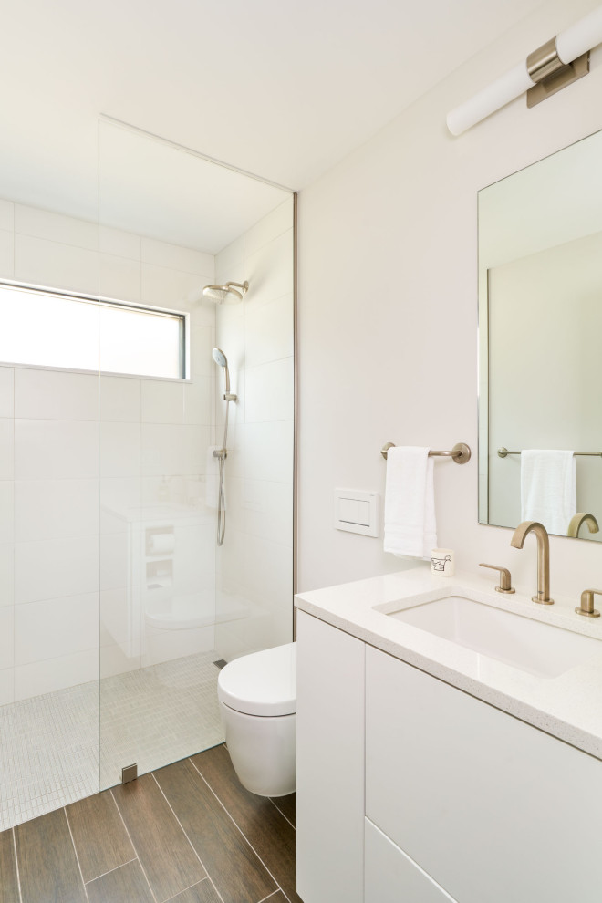 Idéer för mellanstora funkis vitt en-suite badrum, med släta luckor, vita skåp, en kantlös dusch, klinkergolv i keramik, ett undermonterad handfat, brunt golv, med dusch som är öppen och en vägghängd toalettstol