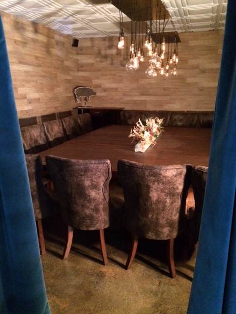 Mid-sized mountain style concrete floor great room photo with brown walls and no fireplace