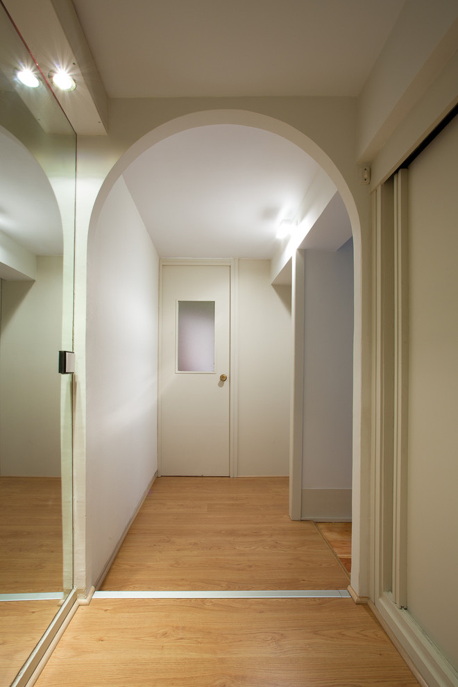 Diseño de armario vestidor unisex clásico renovado de tamaño medio con armarios con paneles lisos y suelo de madera en tonos medios