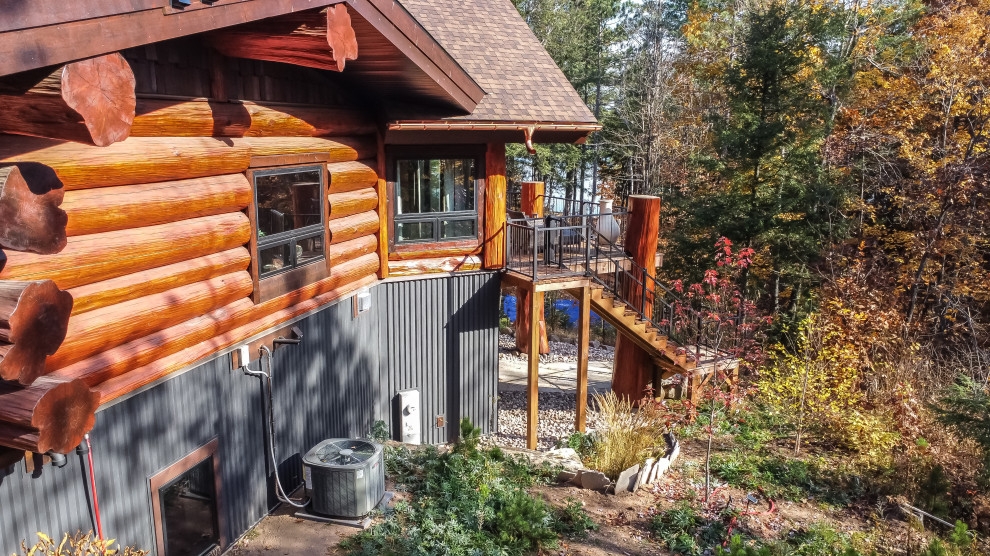 Mid-sized mountain style brown three-story wood and board and batten gable roof photo with a shingle roof and a brown roof