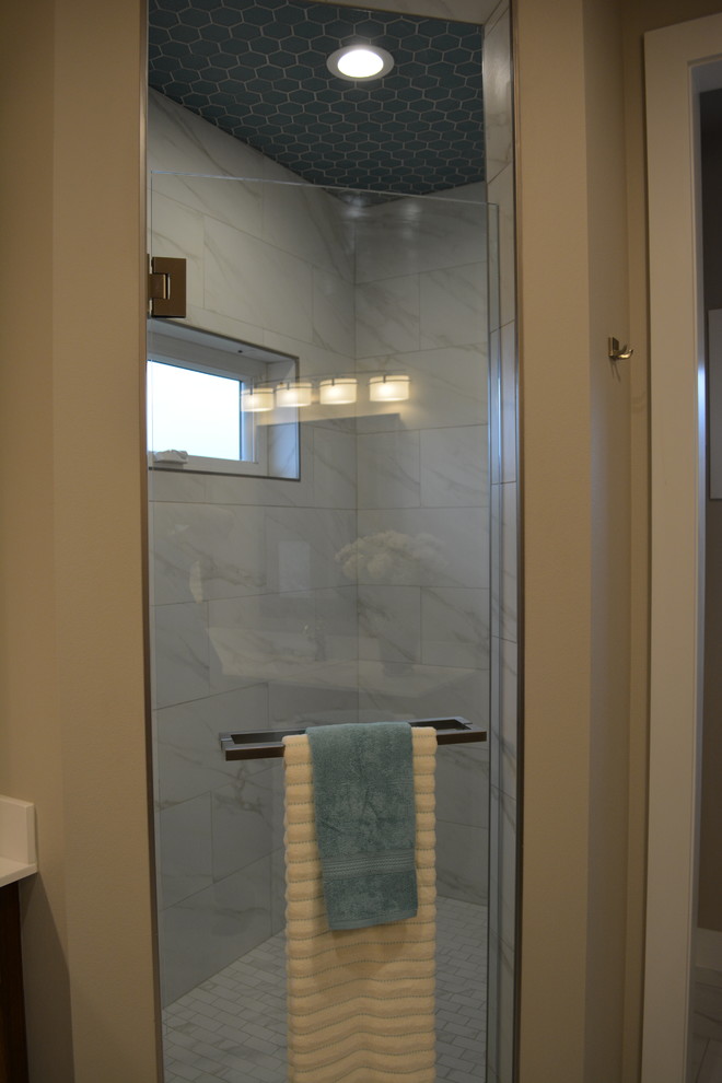 Example of a mid-sized transitional master black and white tile and stone tile porcelain tile alcove shower design with raised-panel cabinets, medium tone wood cabinets, solid surface countertops, beige walls and an integrated sink