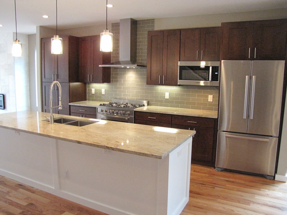Inspiration for a mid-sized transitional medium tone wood floor open concept kitchen remodel in Denver with an undermount sink, shaker cabinets, dark wood cabinets, granite countertops, gray backsplash, glass tile backsplash, stainless steel appliances and an island