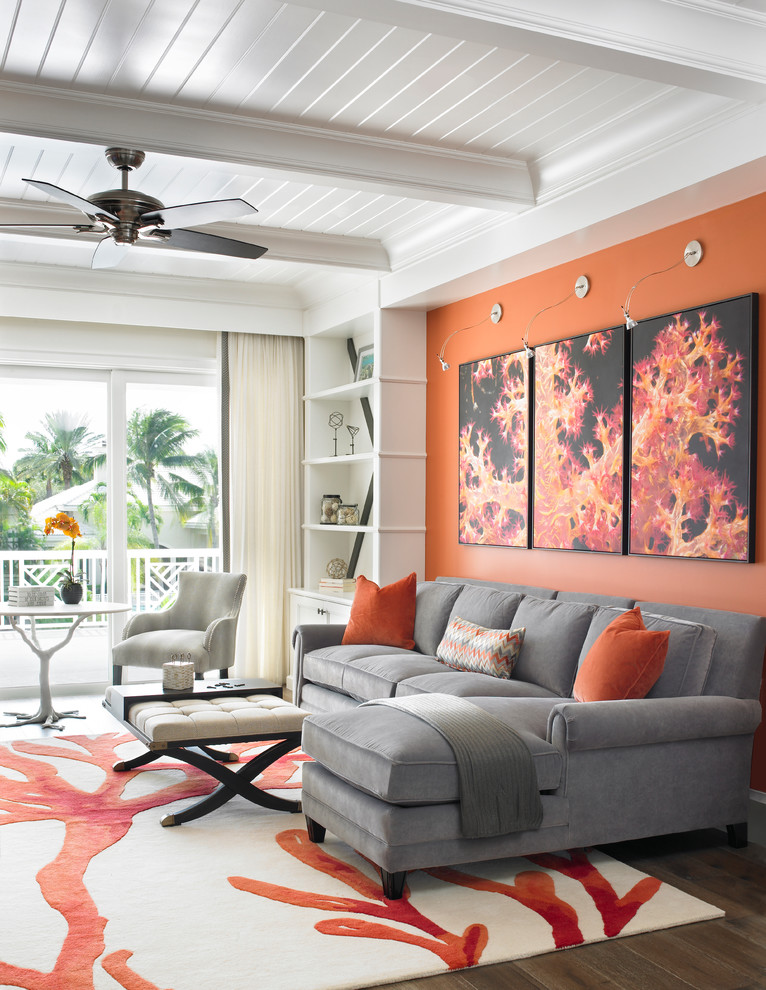 Photo of a transitional open concept living room in Miami with orange walls and dark hardwood floors.