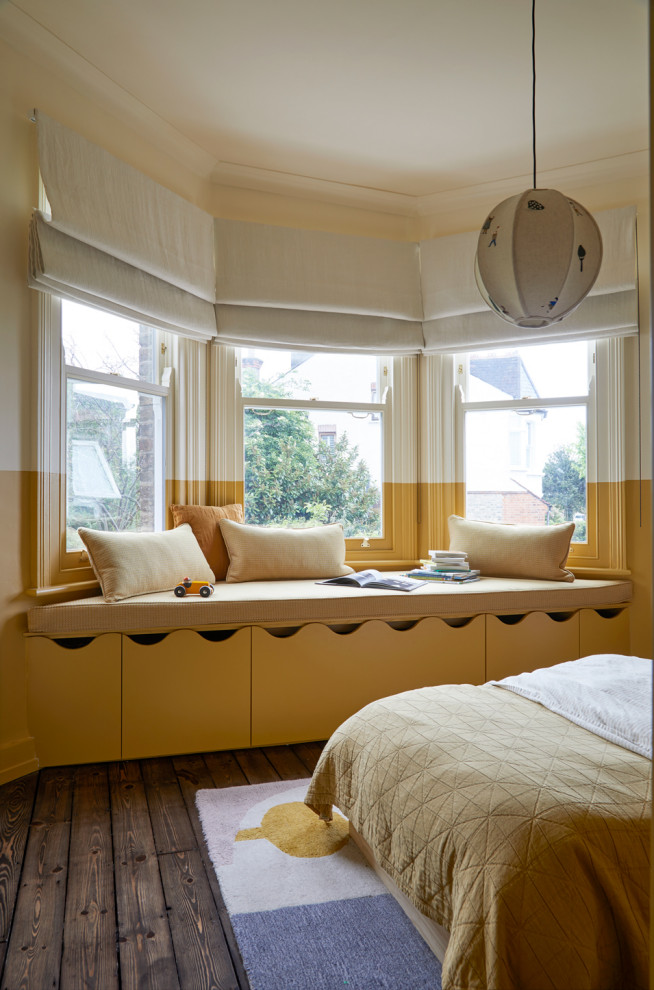 Esempio di una cameretta per bambini da 1 a 3 anni tradizionale di medie dimensioni con pareti gialle, parquet scuro e pavimento marrone