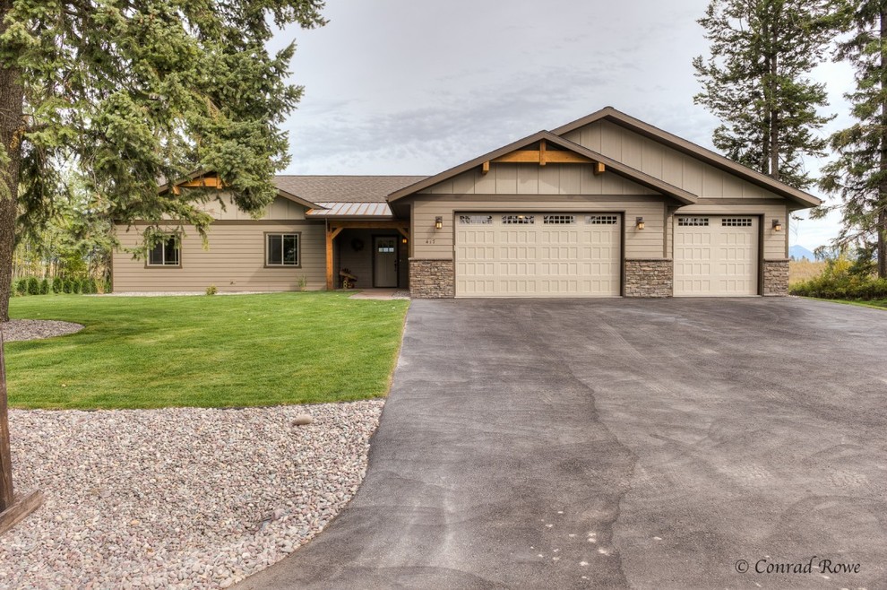 This is an example of a mid-sized rustic partial sun driveway with medium tone wood cabinets and an island for spring.