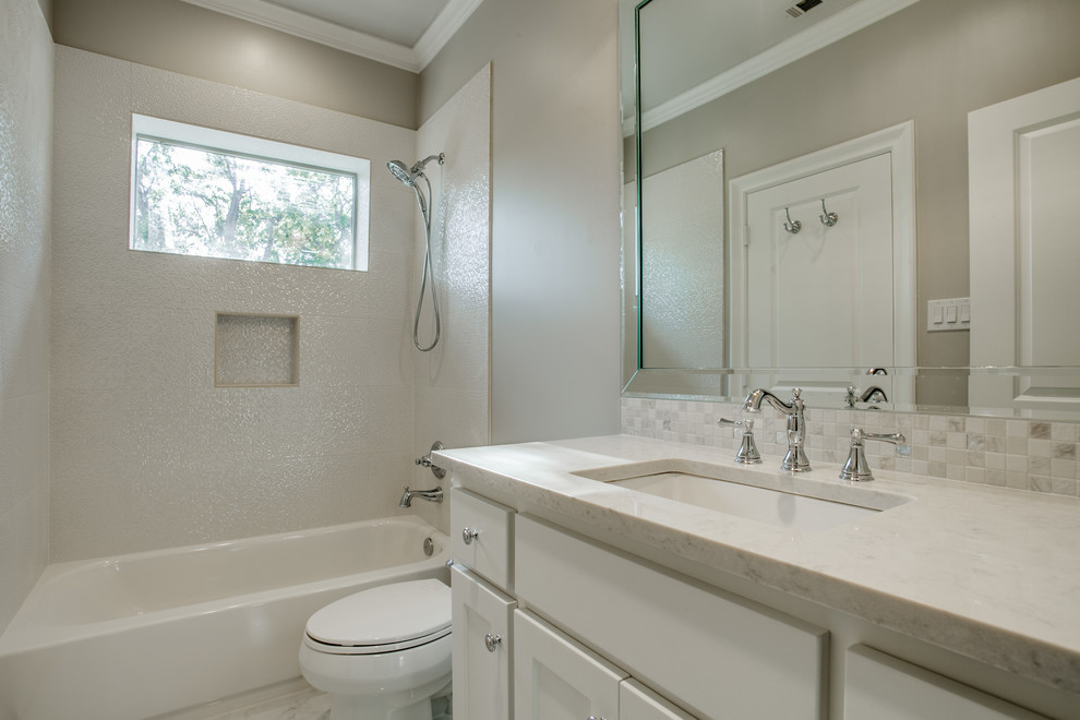 This is an example of a transitional kids bathroom in Dallas with recessed-panel cabinets, marble benchtops, an alcove tub, a shower/bathtub combo, white tile, mosaic tile and grey walls.