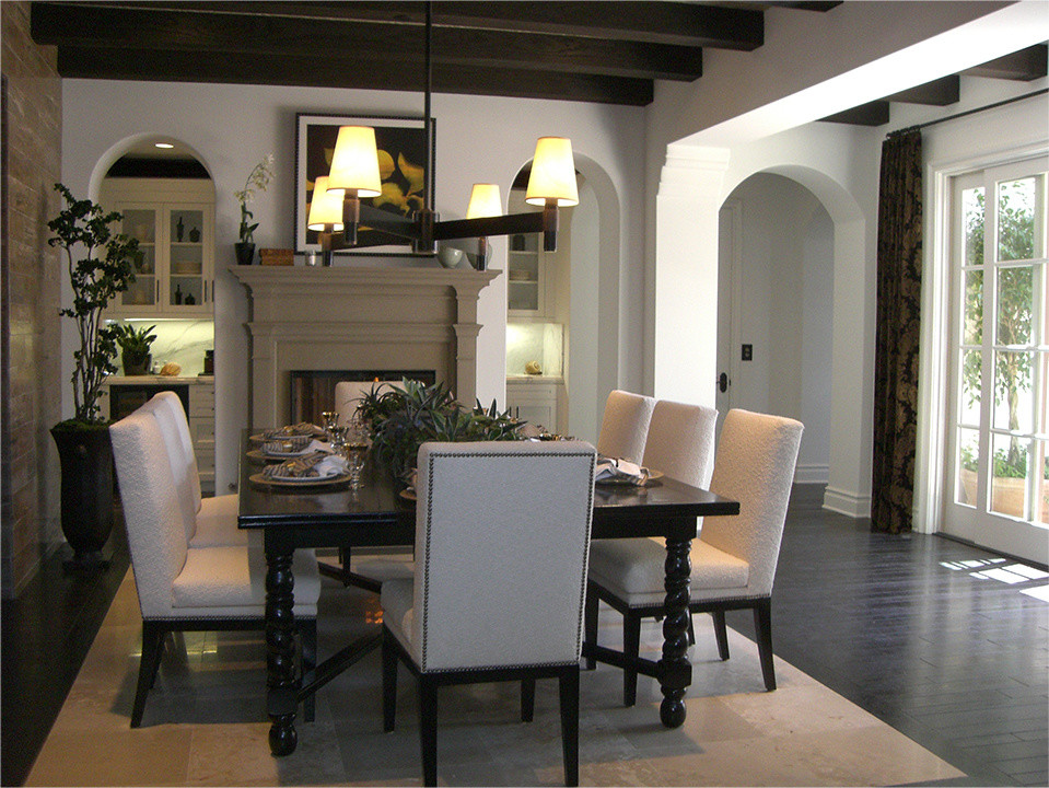 Photo of an expansive traditional separate dining room in Orange County with white walls, porcelain floors, a two-sided fireplace and a wood fireplace surround.