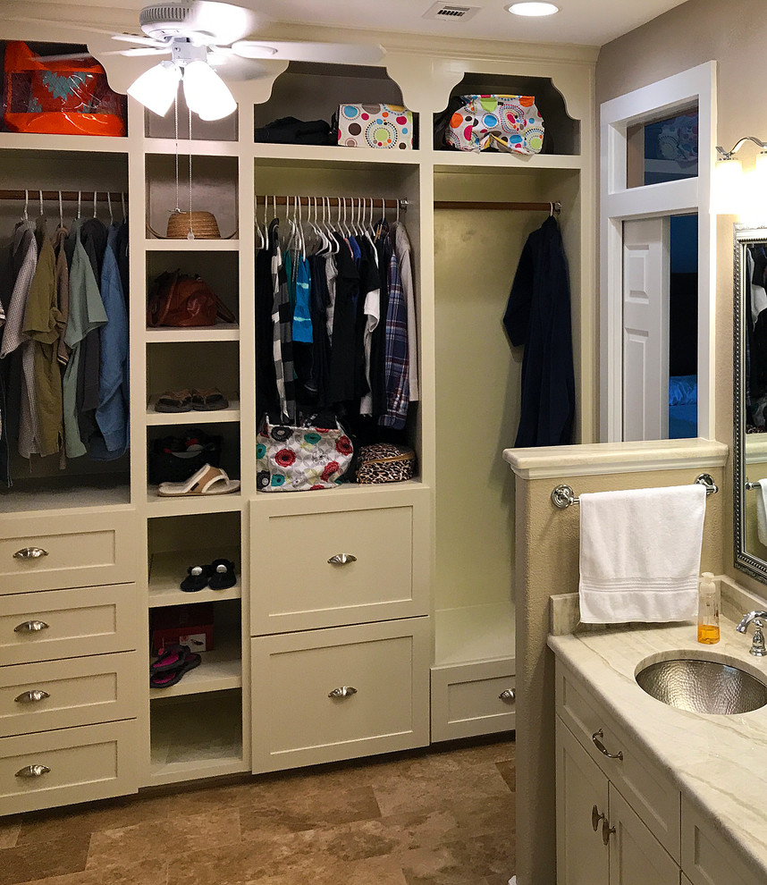 Design ideas for a small traditional gender-neutral built-in wardrobe in Austin with open cabinets, beige cabinets, travertine floors and brown floor.