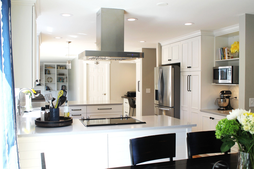 Inspiration for a mid-sized transitional u-shaped medium tone wood floor eat-in kitchen remodel in Seattle with an undermount sink, shaker cabinets, white cabinets, quartz countertops, white backsplash, ceramic backsplash, stainless steel appliances, a peninsula and gray countertops