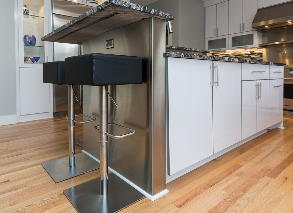Inspiration for a large contemporary u-shaped light wood floor open concept kitchen remodel with an undermount sink, flat-panel cabinets, white cabinets, granite countertops, multicolored backsplash, mosaic tile backsplash, stainless steel appliances and an island